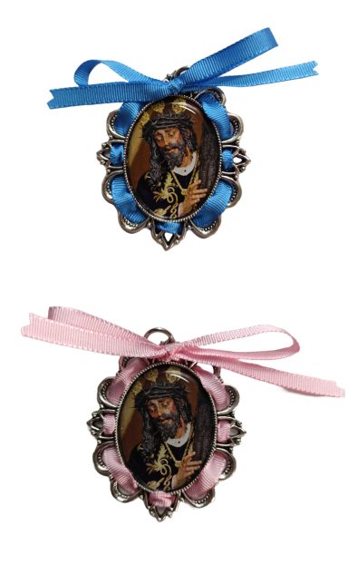 Dos medallones decorativos, uno con cinta azul y otro con cinta rosa, ambos con retratos.
